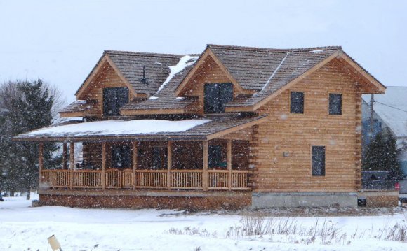 Two-story log house in winter
