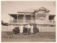 Family with car & Queenslander house.